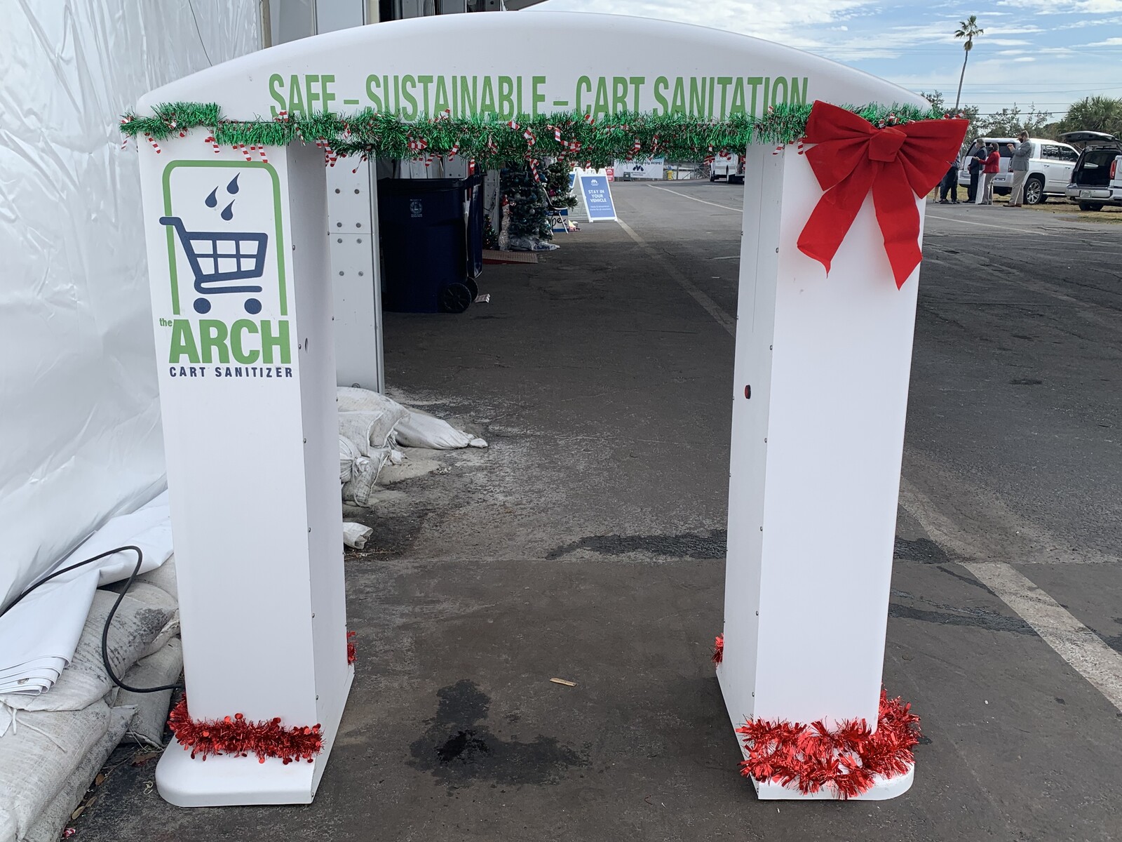 ArchClean cart sanitation arch outdoors with holiday garland and a red bow